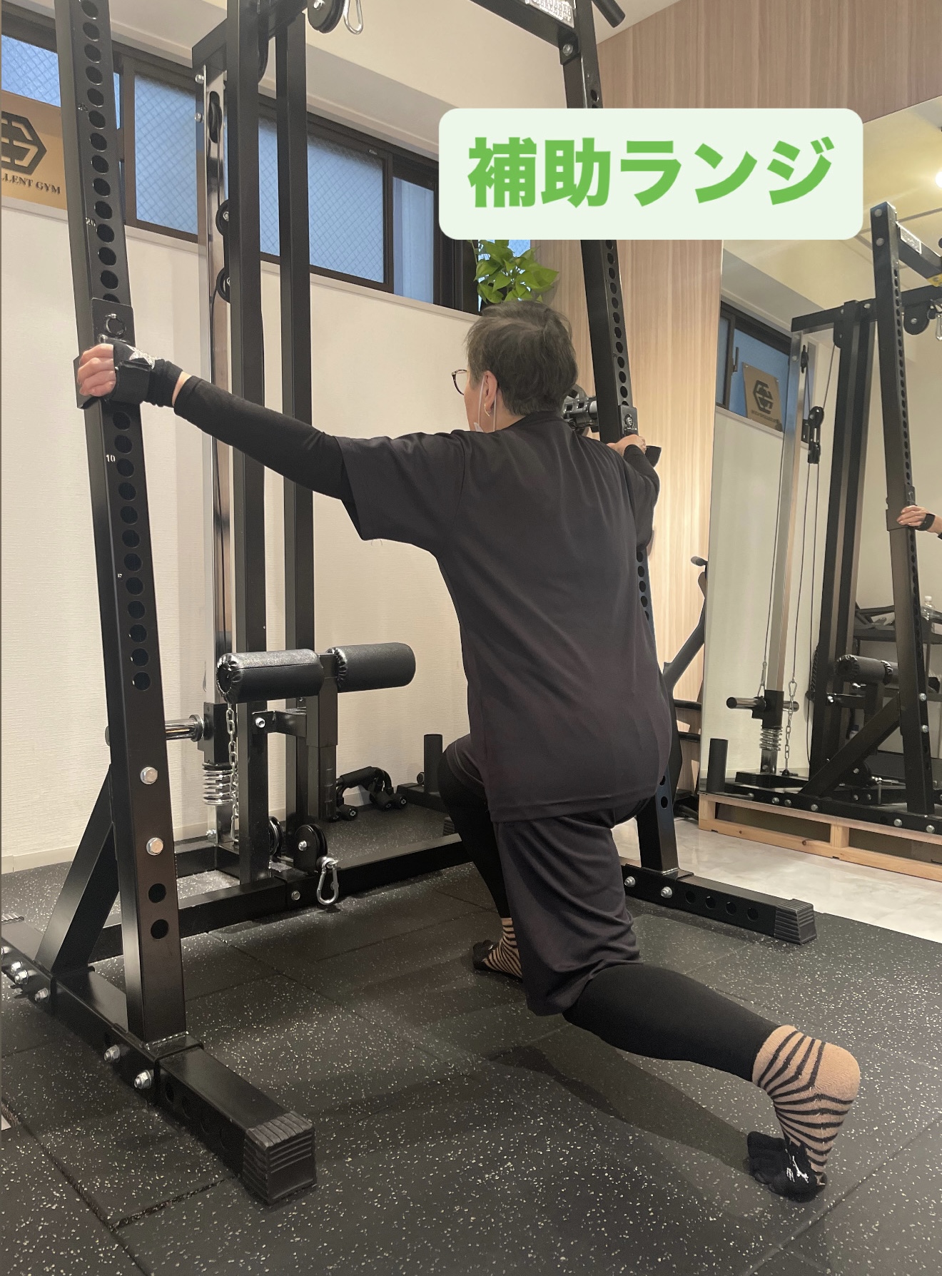 60代の男性がマンツーマン指導で、安全に配慮しながら補助ランジに取り組んでいる様子