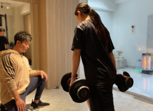 30代以降の女性がパーソナルトレーナーのサポートを受けながら、ヒップアップを目的とした、お尻のトレーニングを行っている様子。