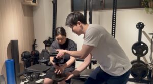 30代以降の女性がパーソナルトレーニング中にトレーニングのやり方を教えている様子。