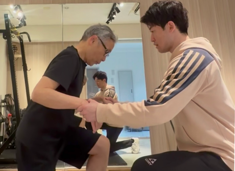 シニア専門パーソナルジムでで立ち上がり動作をサポートするトレーニングの様子